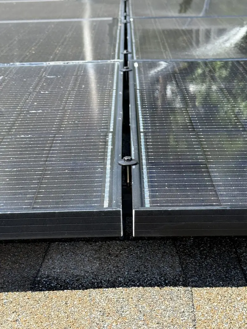 Close-up of clean solar panel seam and mounting hardware